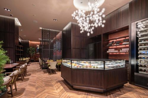 a restaurant with a chandelier and tables and chairs at Hotel GrandBach Tokyo Ginza in Tokyo