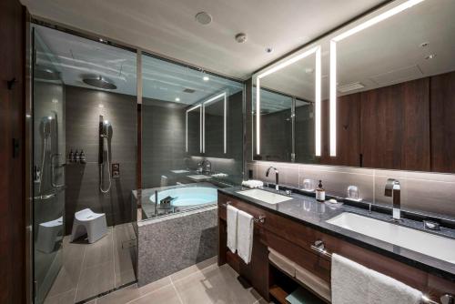 a bathroom with two sinks and a shower and a tub at Hotel GrandBach Tokyo Ginza in Tokyo