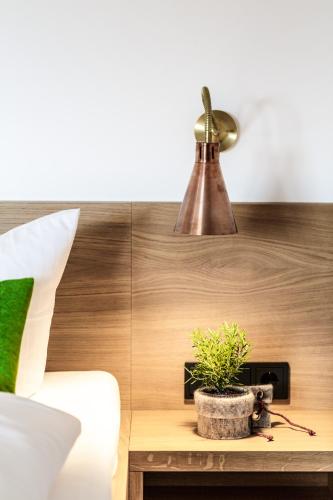 a lamp and a potted plant on a wooden table at KurOase im Kloster in Bad Wörishofen