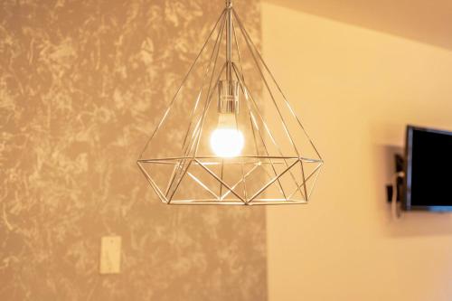a glass light fixture hanging from a ceiling at Chalet Osmar Suite 2 in Campitello di Fassa