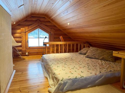 a bedroom with a bed in a wooden cabin at Villa Konnekoski, pearl front of Etelä-Konnevesi National park in Rautalampi