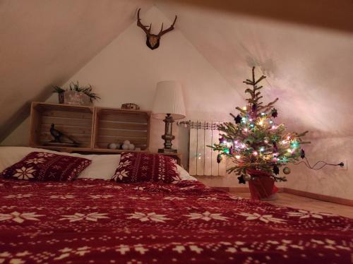 a bedroom with a christmas tree and a bed at Domek dla dwojga in Tylicz