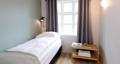 a small bedroom with a bed and a window at Old Charm Reykjavik Apartments in Reykjavík