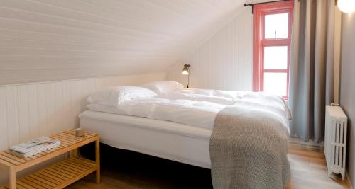 a bedroom with a white bed and a table at Old Charm Reykjavik Apartments in Reykjavík