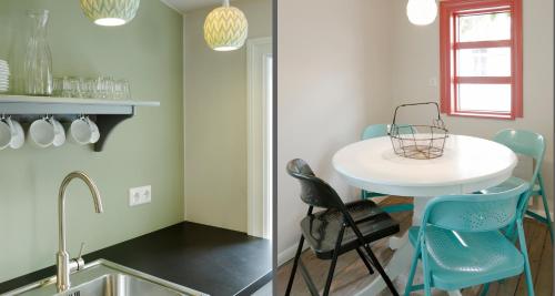 a kitchen with a white table and blue chairs at Old Charm Reykjavik Apartments in Reykjavík