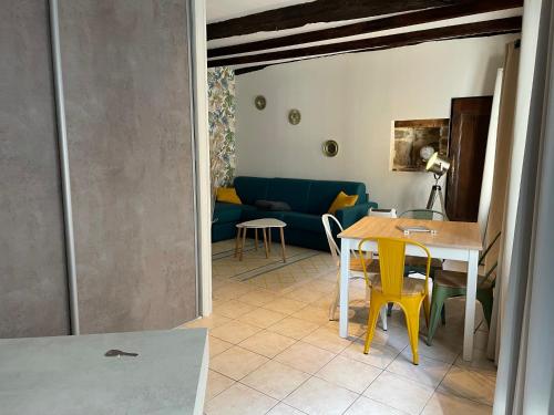 ein Wohnzimmer mit einem Tisch und einem blauen Sofa in der Unterkunft Les gîtes de Madline, Le petit Solidor in Saint-Malo