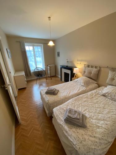 a bedroom with two beds and a desk in it at Le Martin Pêcheur in Port-en-Bessin-Huppain