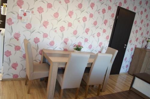 a dining room table and chairs with pink flowers on a wall at Grand Budapest Penthouse in Budapest