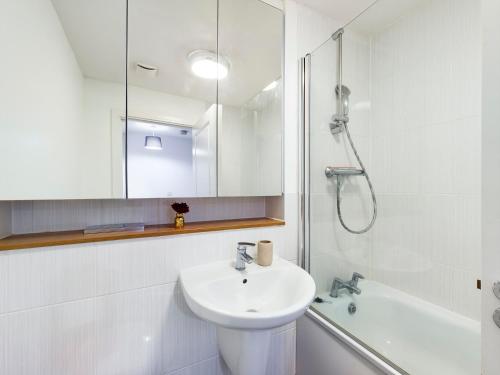 a white bathroom with a sink and a shower at Cheerful 5-BDR/3-BATH House w/ Free Parking in Reading