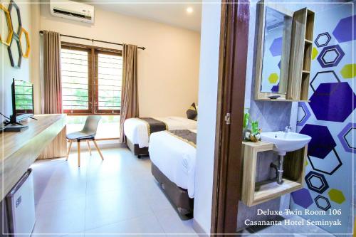 a hotel room with two beds and a sink at Casananta Seminyak in Seminyak