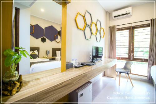 a bedroom with a bed and a desk with a computer at Casananta Seminyak in Seminyak