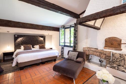 1 dormitorio con 1 cama extragrande y chimenea en Casa9 Hôtel, en Thuir