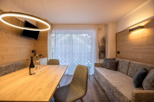 a living room with a table and a couch at Apartments Armeri Blue Dolomites in San Vigilio Di Marebbe