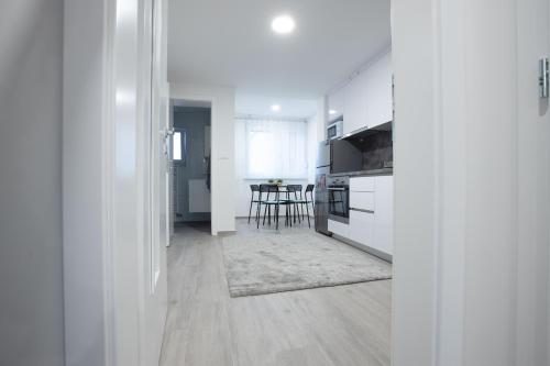 a kitchen with white cabinets and a table in it at Apartmani Dora in Požega