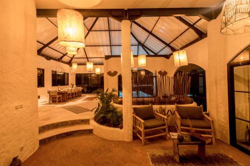 a lobby with chairs and tables and a glass ceiling at Drop In Surf Lodge in Kuta Lombok