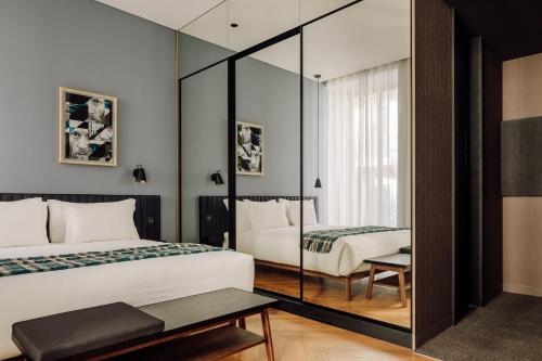 a bedroom with two beds and a mirror at Hotel Hotel - Member of Design Hotels in Lisbon