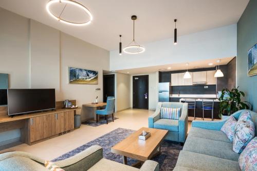 a living room with a couch and a tv at Boudl Al Jubail in Al Jubail