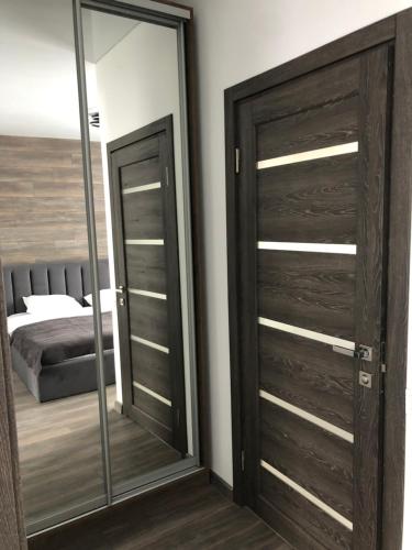 a bedroom with a wooden door and a mirror at ApartHotel in Mukacheve