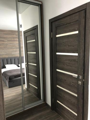 um quarto com uma porta de madeira e um espelho em ApartHotel em Mukacheve