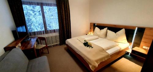 a bedroom with a bed and a desk and a window at Haus Klager in Ramsau am Dachstein