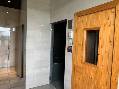 a bathroom with a shower and a wooden door at Kuantan Seaview Studio@Imperium Residence TgLumpur in Kuantan