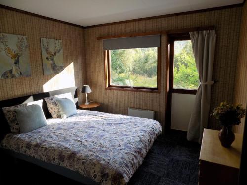 Un dormitorio con una cama grande y una ventana en Kråkehaugen Feriehus, a perfect holiday retreat near Åheim en Åheim
