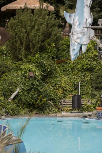 a statue of a shark jumping out of a swimming pool at Landhotel Grimmeblick in Winterberg