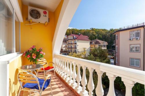 balcón con mesa, sillas y vistas en Medovaya Hotel, en Adler