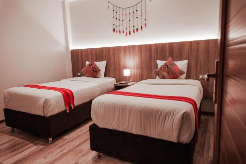 a hotel room with two beds and a chandelier at Casa Matara Boutique in Cusco