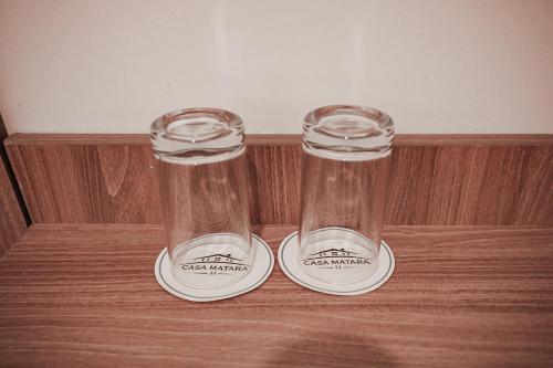 two glass bottles sitting on top of a wooden table at Casa Matara Boutique in Cusco