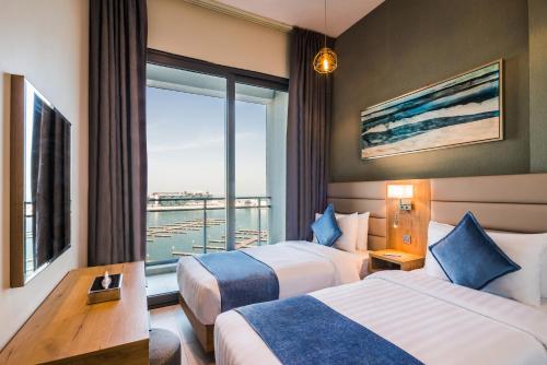 a hotel room with two beds and a large window at Boudl Al Jubail in Al Jubail