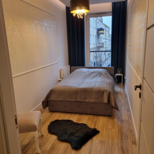 sypialnia z łóżkiem, oknem i krzesłem w obiekcie Apartament Skarbowa w mieście Leszno