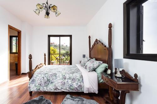 a bedroom with a bed and a table and a window at Home2Book Amazing Teide View & Terrace in Sauzal