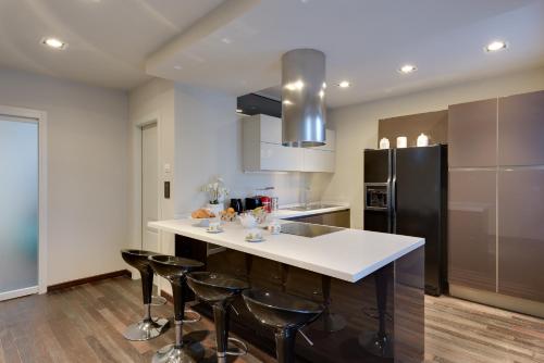 a kitchen with a white counter and black refrigerator at PALAZZO DUOMO Suites in Udine Center in Udine