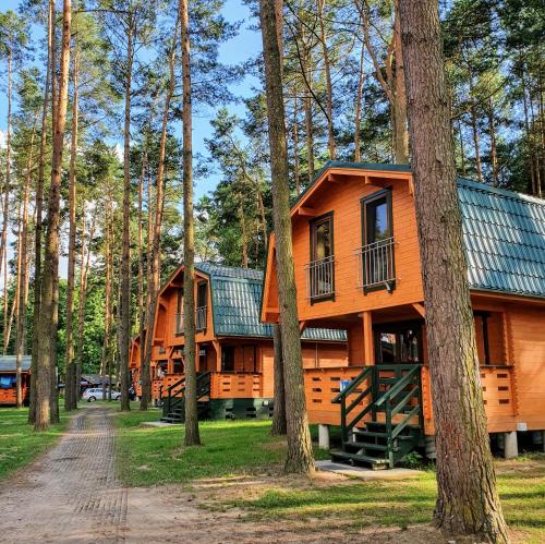 eine Hütte in den Bäumen mit einem Feldweg davor in der Unterkunft Ośrodek Wypoczynkowy Kormoran Niesulice in Niesulice