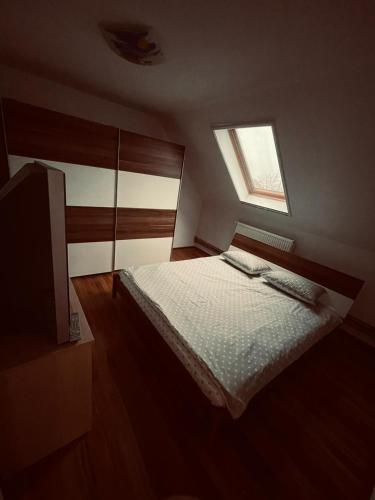 um pequeno quarto com uma cama e uma janela em Casa Verde em Foeni