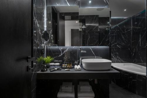 a black bathroom with a sink and a mirror at No 15 Ermou Hotel in Thessaloniki