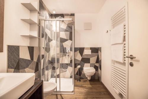 uma casa de banho com um WC e uma cabina de duche em vidro. em Apartment Ön Residence Bun Ste em San Vigilio Di Marebbe