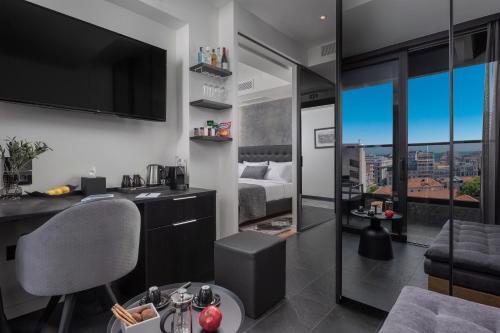 a room with a bedroom with a bed and a tv at No 15 Ermou Hotel in Thessaloniki
