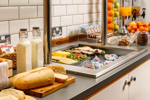 a breakfast buffet with bread and bottles of milk at ibis Styles Birmingham Centre in Birmingham