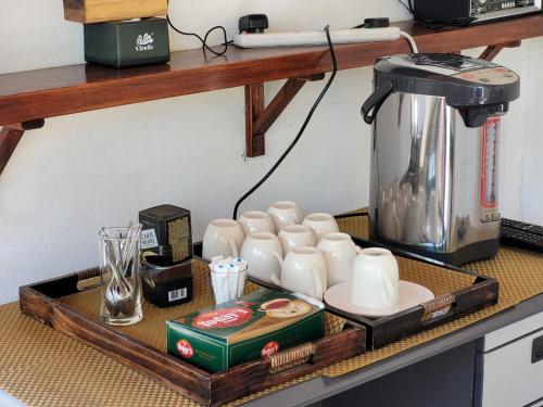 a counter with a coffee maker and cups on it at Alesara Guest House in Thoddoo