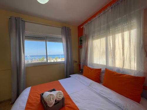 a bedroom with a bed and a window with the ocean at Breezot Yam in Nahariyya