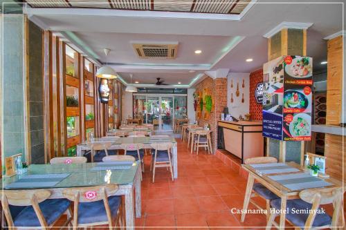 a restaurant with tables and chairs in a room at Casananta Seminyak in Seminyak