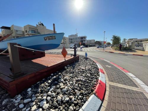 a boat sitting on the side of a road at Breezot Yam in Nahariyya