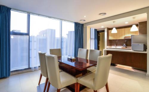 a dining room table and chairs in a hotel room at Boudl Al-Jubail - Danah Al-Jubail Suites in Al Jubail