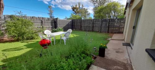 a backyard with a white table and chairs and a fence at Migdal Oz aka Rufpatch in Smithfield