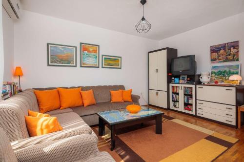 een woonkamer met een bank en een tafel bij Apartment Oaza in Supetar