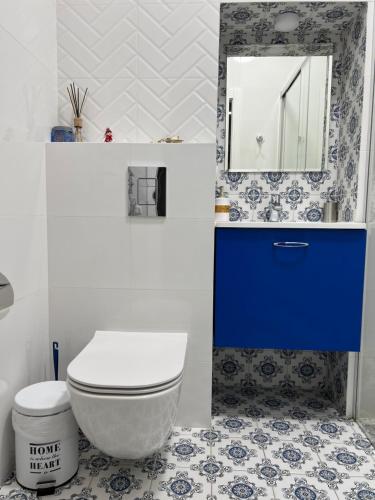 a bathroom with a white toilet and a blue cabinet at Delux apartment in Lviv in Lviv
