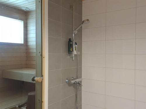 a shower in a bathroom with a glass door at Uusi loma-asunto 4 hengelle hiekkasärkillä in Kalajoki