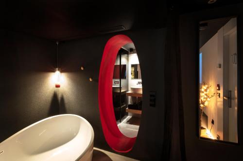 a bathroom with a white sink and a red oval mirror at Zrooms&Suites Hostel Boutique in Zaragoza